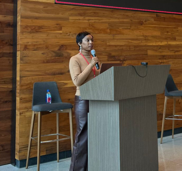 Candice White speaking at a podium during a keynote session